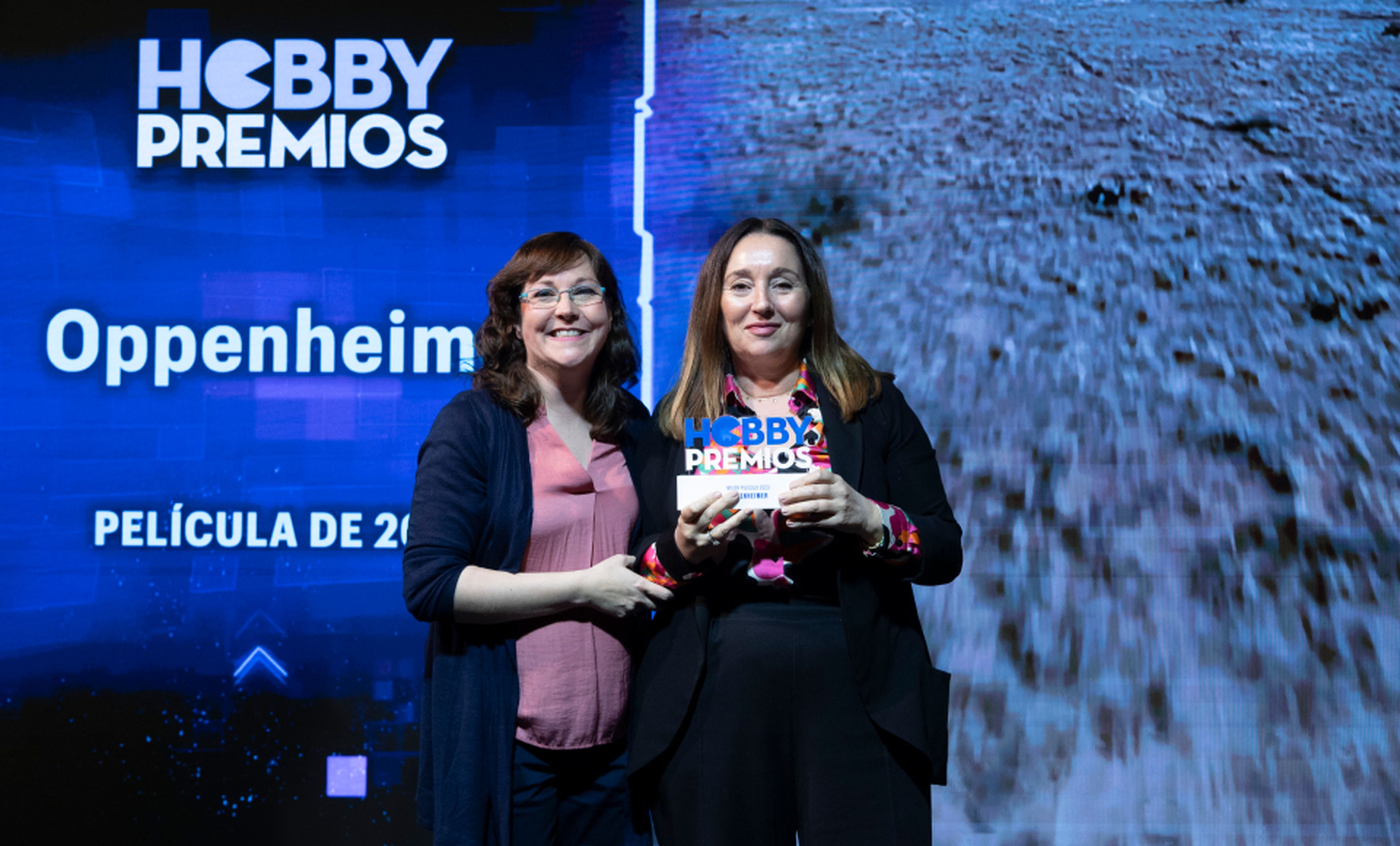 Leonor Martínez, directora de marketing de Universal Pictures recoge de manos de Raquel Hernández, redactora de HobbyCine el premio a mejor película para Oppenheimer.